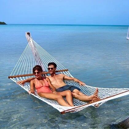 Couple on the overwater hammocks at the Beach Club by Mahogany Bay Resort San Pedro Ambergris Caye Belize