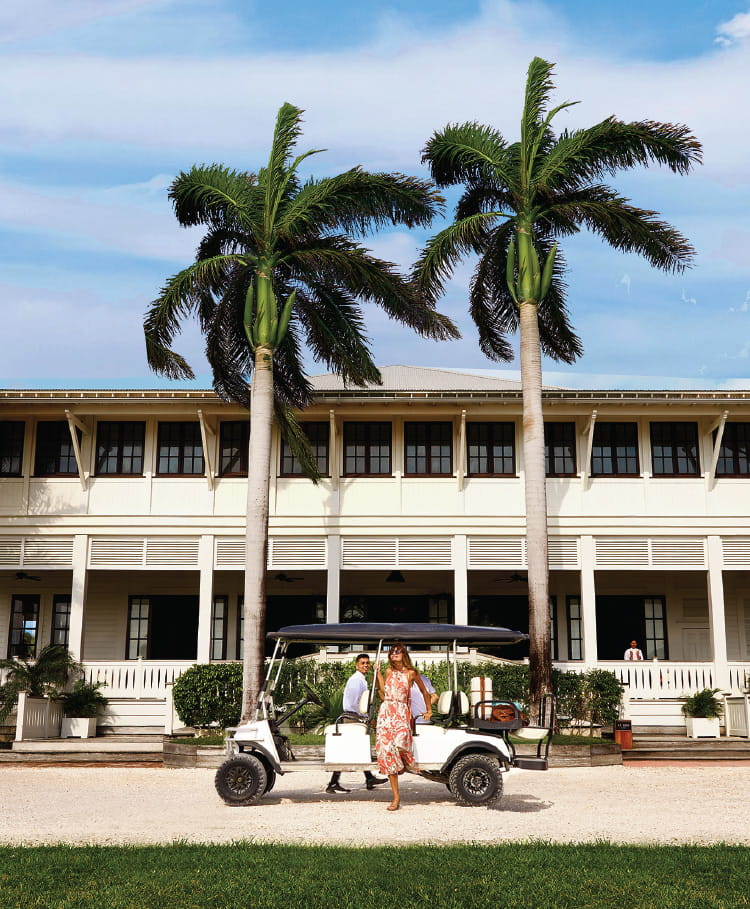 Women exiting golf cart in front of the Great House at Mahogany Bay Resort & Beach Club